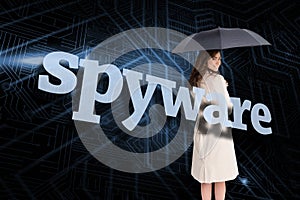 Businesswoman holding umbrella behind the word spyware