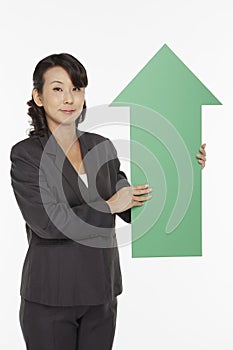 Businesswoman holding up a green arrow