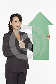 Businesswoman holding up a green arrow