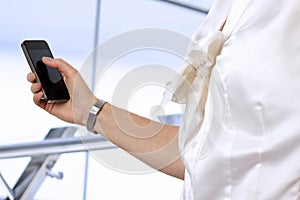 Businesswoman holding and using the mobile phone