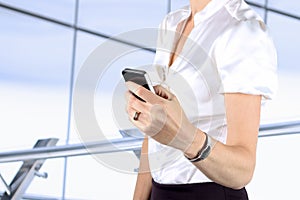 Businesswoman holding and using the mobile phone