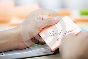 Businesswoman holdings sticky note with Thank you text