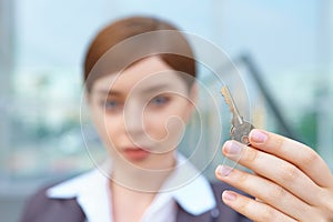 Businesswoman holds door key.