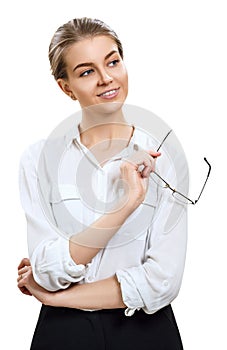 Businesswoman holds glasses in hands and looking away.