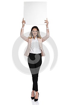 Businesswoman holds white board up in the air