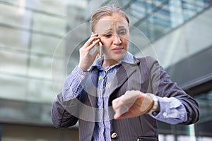 Businesswoman hurrying and watching on wristwatch