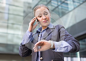 Businesswoman hurrying and watching on wristwatch