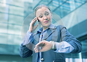 Businesswoman hurrying and watching on wristwatch