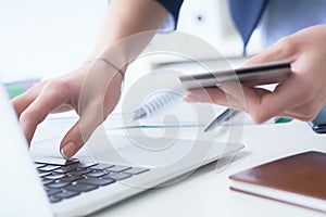 Businesswoman inputting her password and login to carry out online banking operation on laptop pc in the office. Woman`s