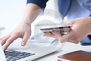 Businesswoman inputting her password and login to carry out online banking operation on laptop pc in the office. Woman`s