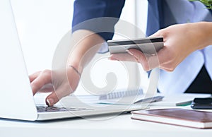 Businesswoman inputting her password and login to carry out online banking operation on laptop pc in the office. Woman`s