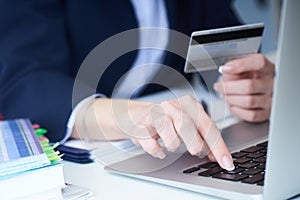 Businesswoman inputting her password and login to carry out online banking operation on laptop pc in the office. Woman`s