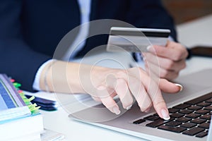 Businesswoman inputting her password and login to carry out online banking operation on laptop pc in the office. Woman`s