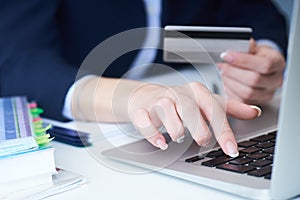 Businesswoman inputting her password and login to carry out online banking operation on laptop pc in the office. Woman`s