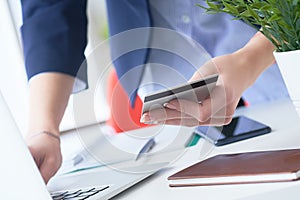 Businesswoman inputting her password and login to carry out online banking operation on laptop pc in the office. Woman`s