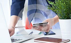 Businesswoman inputting her password and login to carry out online banking operation on laptop pc in the office. Woman`s