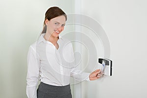 Businesswoman Inserting Keycard In Security System
