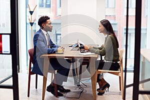 Businesswoman Interviewing Male Job Candidate In Meeting Room photo