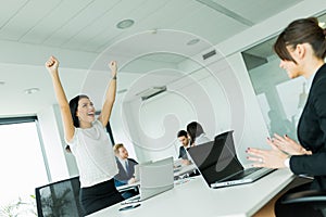 Businesswoman jumping from joy and raises hands as a sign of suc