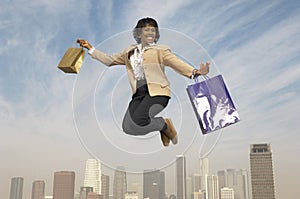 Businesswoman Jumping With Shopping Bags