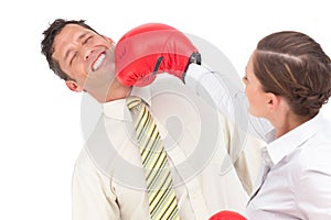 Businesswoman knocking out a businessman with boxing gloves