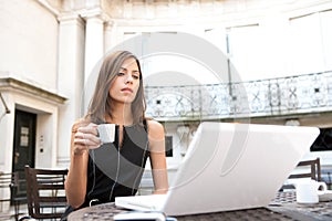 Businesswoman with laptop in cafe.