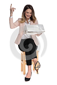 Businesswoman laughing while reading paper and pointing finger up