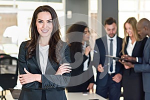 Businesswoman leader in modern office with businesspeople working at background