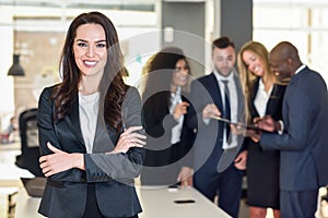 Businesswoman leader in modern office with businesspeople working at background