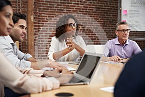 Businesswoman Leading Office Meeting Of Colleagues Sitting Around Table photo