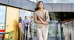 Businesswoman Leads a Confident Stride in Modern Office Environment During a Sunny Afternoon