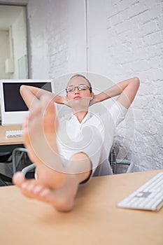 Businesswoman with legs crossed at ankle on desk