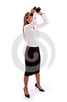 Businesswoman looking through binocular