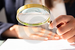 Businesswoman Looking At Contract Form Through Magnifying Glass