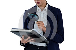 Businesswoman looking at document through magnifying glass