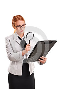 Businesswoman looking at document through magnifying glass