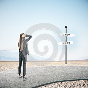 Businesswoman looking on easy and hard sign post