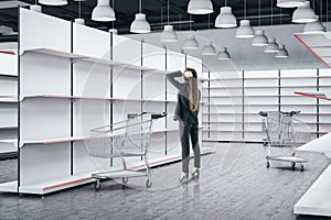 Businesswoman looking on empty retail shelves