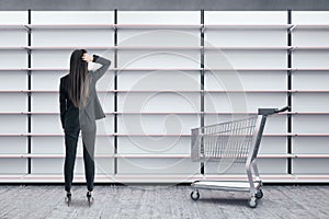 Businesswoman looking on empty shop white shelves