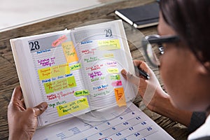 Businesswoman Looking At List Of Business Work In Diary