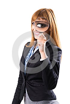 Businesswoman looking through magnifying glass