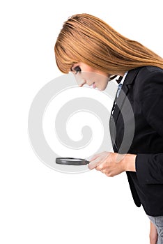 Businesswoman looking through magnifying glass