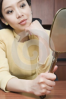 Businesswoman looking at mirror
