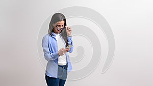 Businesswoman looking out through glasses and reading message over mobile phone on white background