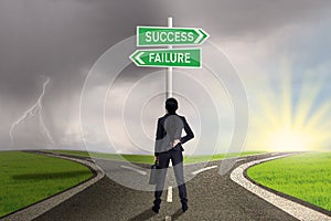 Businesswoman looking at sign of success or failure photo