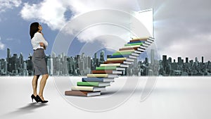 Businesswoman looking at stair made of books in front of a city