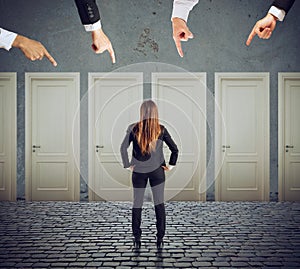 Businesswoman looking to select the right door. Concept of confusion and competition