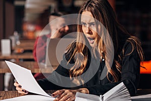 The businesswoman looks at the documents in shock