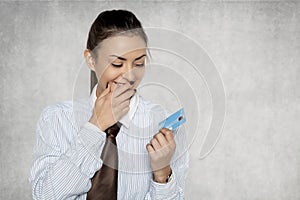 Businesswoman looks with great joy at the bank card