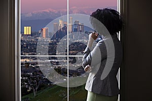 Businesswoman in Los Angeles Looking at Office Window